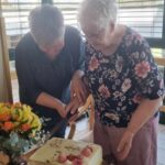 Dve starejši ženski režeta torto.