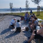 Več ljudi sedi na plaži.