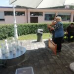 Starejša ženska se pripravlja na met krogle pri ruskem kegljanju na prostem.