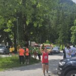Ženska priteče v cilj z dvignjenimi rokami.