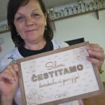 Ženska v rokah drži napis "Silva ČESTITAMO dočakala si penzijo!".
