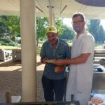 Dva moška stojita in skupaj v rokah držita krožnik s pečenimi jajci.