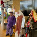 Trije moški, oblečeni v kostume Svetih treh kraljev, stojijo v prostoru. Eden nosi vijolično obleko, v rokah drži okrašeno zvezdo in škatlo. Drugi ima belo pokrivalo in dolgo rjavo tuniko, tretji pa nosi zlato-rdeč plašč in krono. Prostor je okrašen s prazničnimi elementi, vključno s snežakom na stebru.