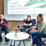 Trije sogovorniki sedijo pred projekcijskim platnom z naslovom filma "V mojih sanjah rase vsako noč drevo"; starejši moški v invalidskem vozičku govori v mikrofon, ob njem sedita mlajši moški in ženska.