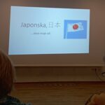 Predavanje o Japonski z naslovnim diapozitivom in sliko zastave Japonske na projekcijskem platnu.