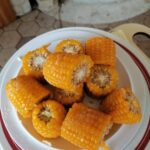 Krožnik s kuhanimi koruznimi storži, narezanimi na manjše kose, posutimi s soljo.