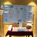 Bela tabla z informacijami o svetovnem dnevu Alzheimerjeve bolezni in ozaveščanju o demenci, pred njo pa miza z zloženkami in gradivi.
