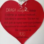 Veliko rdeče srce na steni z napisom voščila ob 100. rojstnem dnevu.