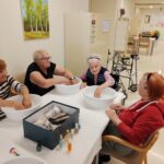 Stanovalke med sproščujočo nego rok s toplo kopeljo in prijetnim pogovorom.