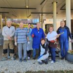 Skupina stanovalcev in zaposlenih ponosno pozira po uspešno opravljenem delu.