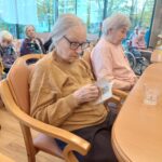 Stanovalka v naslanjaču bere knjižico o Primožu Trubarju.