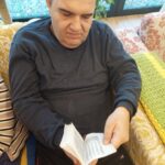 Moški prebira knjigo in obrača strani med dogodkom.