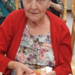 Stanovalka ponosno pokaže svoj sendvič, pripravljen za pokušino.