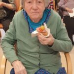 Stanovalka s sendvičem v roki sodeluje pri obeležitvi dneva sendvičev.