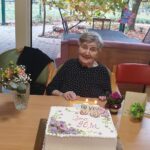 Stanovalka praznuje 96. rojstni dan ob torti in cvetličnih aranžmajih.