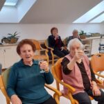 Stanovalke dvigujejo kozarce in nazdravljajo ob prazničnem druženju.