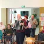 Trije glasbeniki z harmoniko, klarinetom in spremljevalko nastopajo ob martinovanju.