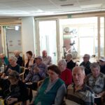 Stanovalci sedijo v dvorani in spremljajo martinovanje.