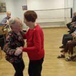 Dve stanovalki plešeta ob glasbi med martinovanjem v domu.