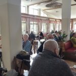 Stanovalci med druženjem sedijo v jedilnici doma.