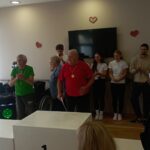 Stanovalci prejmejo medalje ob aplavzu skupine.