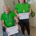 Dva stanovalca s športnimi medaljami in zahvalnicama pozirata za fotografijo.