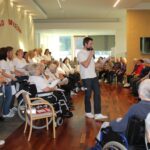 Zaposleni in stanovalci skupaj pojejo na pevskem in bralnem koncertu doma.