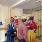 Klovn piha milne mehurčke, drugi klovn pa igra na ukulele in zabava stanovalce.