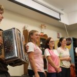 Zaposlene in harmonikar skupaj pripravijo glasbeno točko za stanovalce.