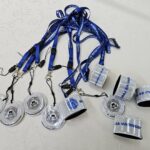 Komplet odsevnih pripomočkov in modrih vratnih trakov z logotipom policije, pripravljenih za razdelitev.