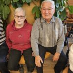 Stanovalec in stanovalka sedita skupaj ob notranji rastlini.