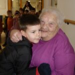 Stanovalka objema in tolaži dečka iz vrtca med obiskom.