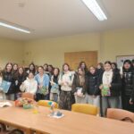 Skupina dijakov stoji v prostoru doma starejših in v rokah drži knjige ter drobna darila.