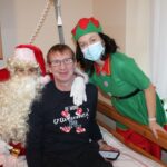 Božiček in palčica na obisku pri stanovalcu v sobi doma.