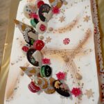 Velika praznična torta, okrašena s piškoti, makroni in božičnimi motivi.