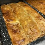 Pečen zavitek z zlato rjavo skorjo na pekaču v kuhinji.