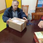 Stanovalec ob odpiranju prazničnega darila, ki je bilo pripravljeno v okviru decembrskega obdarovanja.