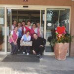 Zaposleni pozirajo pred vhodnimi vrati enote Park Kidričevo; ob straneh vhoda sta velika cvetlična lonca z okrasnimi srci.