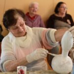 Stanovalka se posveča detajlom in skrbno nanaša barvo, kar kaže na veliko mero potrpežljivosti in ustvarjalnosti.