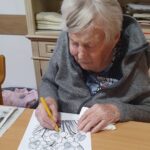 Starejša ženska barva risbo cvetov na papirju z barvico.