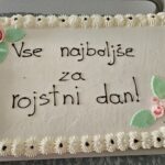 Torta z napisom »Vse najboljše za rojstni dan!« je okrašena s kremo in cvetličnimi motivi.