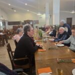 Stanovalci ob praznovanju uživajo ob torti in pijači ter prijetnem druženju.