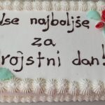 Torta z napisom »Vse najboljše za rojstni dan!« je okrašena s kremo in cvetličnimi motivi.