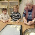 Skupaj pripravljajo testo za velikonočne dobrote, kjer se prepletata učenje in prijetno druženje.