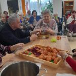 Stanovalci skupaj pripravljajo naravne materiale za barvanje pirhov, ob tem pa prijetno klepetajo.