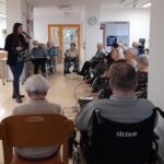 Ob sproščenem druženju stanovalci pozorno poslušajo in uživajo v programu, ki popestri njihov vsakdan.