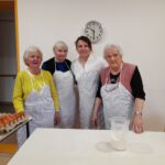 Stanovalke skupaj z zaposleno z veseljem pozirajo v kuhinji, pripravljene na peko velikonočnih dobrot.