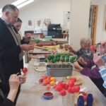 Stanovalci skupaj ustvarjajo in barvajo pirhe, pri tem pa uživajo v druženju in ustvarjalnem delu.