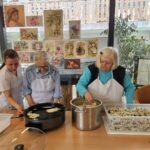 Stanovalki doma za starejše in zaposlena pripravljajo ocvrte akacijeve cvetove.
