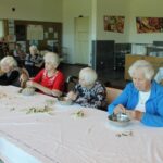 Stanovalke doma za starejše sodelujejo pri čiščenju in pripravi bezgovih cvetov.